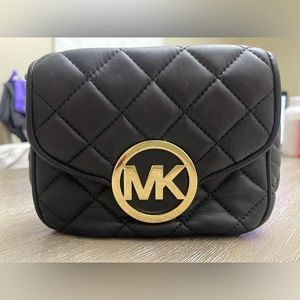 Michael Kors black crossover purse with sticking pattern.